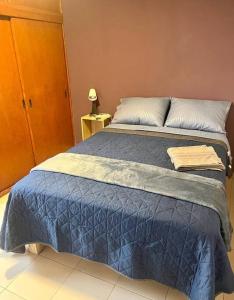 een slaapkamer met een bed met een blauw dekbed bij Depto. equipado, Dos Habitaciones, Centro Tulancingo in Tulancingo