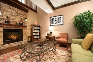 a living room with a fireplace and a glass table at Country Inn & Suites by Radisson, Norcross, GA in Norcross
