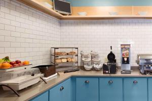 uma cozinha com armários azuis e uma bancada com comida em Country Inn & Suites by Radisson, Brunswick I-95, GA em Brunswick