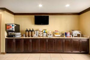 a kitchen with a counter with a tv on the wall at Country Inn & Suites by Radisson, Norcross, GA in Norcross