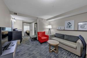ein Wohnzimmer mit einem Sofa und einem roten Stuhl in der Unterkunft Country Inn & Suites by Radisson, Braselton, GA in Braselton