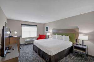 a hotel room with a large bed and a red chair at Country Inn & Suites by Radisson, Braselton, GA in Braselton