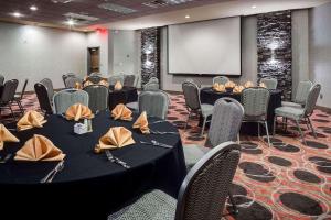 Una sala de conferencias con mesas, sillas y una pantalla. en Holiday Inn Coralville - Iowa City by IHG, en Coralville