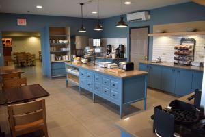 a large kitchen with blue cabinets and a counter at Country Inn & Suites by Radisson, Northwood, IA in Northwood