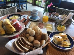 una mesa de madera con platos de comida. en Pousada Benevento, en Campos do Jordão