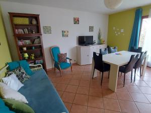 ein Wohnzimmer mit einem Sofa, einem Tisch und Stühlen in der Unterkunft Gîte Velle-sur-Moselle, 3 pièces, 5 personnes - FR-1-584-164 in Velle-sur-Moselle