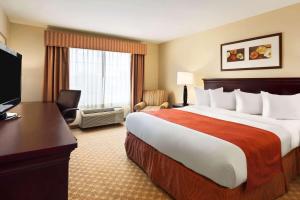 a hotel room with a large bed and a desk at Country Inn & Suites by Radisson, Clinton, IA in Clinton