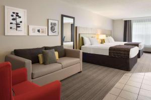 ディコーラにあるCountry Inn & Suites by Radisson, Decorah, IAのベッドとソファ付きのホテルルーム