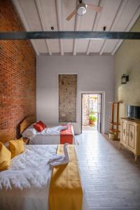 Cette chambre comprend 2 lits et un mur en briques. dans l'établissement Hacienda Gamboa, à Atlixco