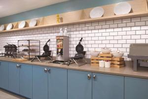 una cucina con bancone e stoviglie di Country Inn & Suites by Radisson, Waterloo, IA a Waterloo