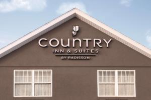 un bâtiment avec le panneau d'une auberge de campagne et de suites dans l'établissement Country Inn & Suites by Radisson, Dubuque, IA, à Dubuque