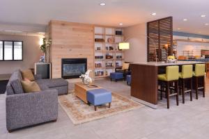 オマハにあるCountry Inn & Suites by Radisson, Omaha Airport, IAのリビングルーム(ソファ付)、キッチン(バー付)