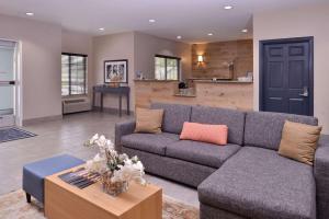 オマハにあるCountry Inn & Suites by Radisson, Omaha Airport, IAのソファとテーブルのあるリビングルーム