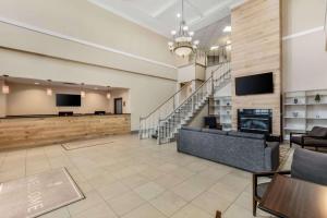 een lobby met een bank, een televisie en een trap bij Country Inn & Suites by Radisson, Elk Grove Village-Itasca in Elk Grove Village