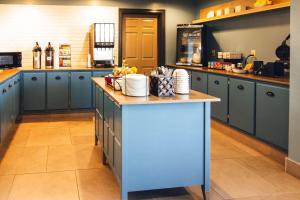 a kitchen with blue cabinets and a blue island at Country Inn & Suites by Radisson, Stockton, IL in Stockton