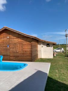 a house with a pool in front of a building at CASA DO BOSQUE in Imbituba