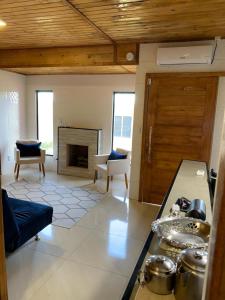 a kitchen with a living room with a fireplace at CASA DO BOSQUE in Imbituba