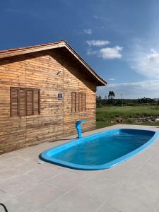 a swimming pool in front of a wooden building at CASA DO BOSQUE in Imbituba
