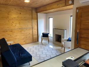 a living room with a blue couch and a fireplace at CASA DO BOSQUE in Imbituba