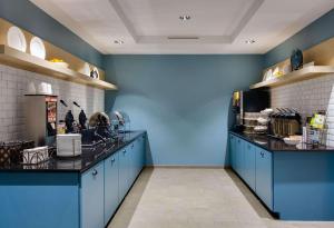 une cuisine avec des murs bleus et un comptoir. dans l'établissement Country Inn & Suites by Radisson, Springfield, IL, à Springfield