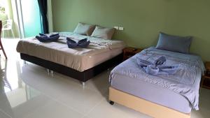 two beds sitting next to each other in a room at Spy home in Khao Lak
