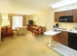 a hotel room with a kitchen and a dining room at Country Inn & Suites by Radisson, Crystal Lake, IL in Crystal Lake
