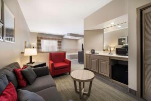 Country Inn & Suites by Radisson, Freeport, IL في Freeport: غرفة معيشة مع أريكة وكرسي احمر