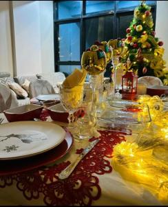 una mesa de Navidad con un árbol de Navidad y copas de vino en Tu hogar en Abancay, en Abancay