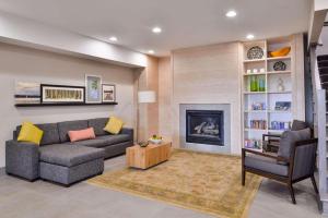 a living room with a couch and a fireplace at Country Inn & Suites by Radisson, Tinley Park, IL in Tinley Park