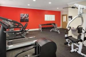 a gym with red walls and tread machines at Country Inn & Suites by Radisson, Champaign North, IL in Champaign