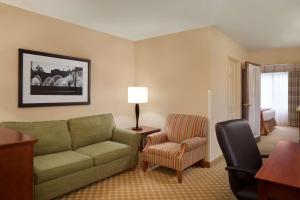 sala de estar con sofá y silla en Country Inn & Suites by Radisson, Champaign North, IL, en Champaign