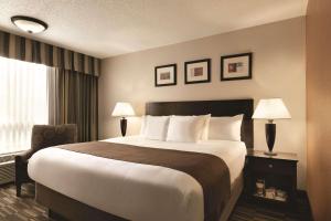 ein Hotelzimmer mit einem großen Bett und einem Fenster in der Unterkunft Radisson Hotel Louisville North in Jeffersonville