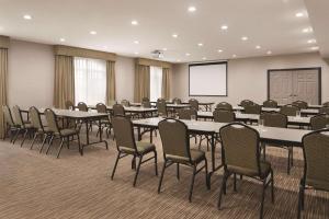 einen Konferenzraum mit Tischen, Stühlen und einem Bildschirm in der Unterkunft Country Inn & Suites by Radisson, Michigan City, IN in Michigan City