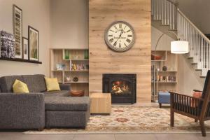 a living room with a clock and a fireplace at Country Inn & Suites by Radisson, Merrillville, IN in Merrillville
