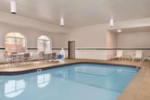 uma grande piscina com cadeiras e uma mesa em Country Inn & Suites by Radisson, Merrillville, IN em Merrillville