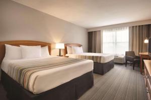 een hotelkamer met 2 bedden en een bureau bij Country Inn & Suites by Radisson, Portage, IN in Portage