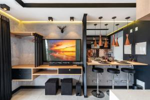cocina con TV y bar con taburetes en MS906 Studio Encantador na Bela Vista, en São Paulo