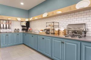 a kitchen with blue cabinets and white tiles at Country Inn & Suites by Radisson, Valparaiso, IN in Valparaiso