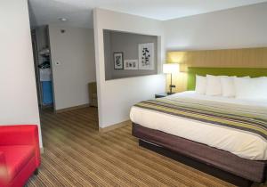 een hotelkamer met een bed en een rode bank bij Country Inn & Suites by Radisson, Greenfield, IN in Greenfield