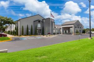 a large building with an american flag in a parking lot at Country Inn & Suites by Radisson, Wichita East, KS in Wichita