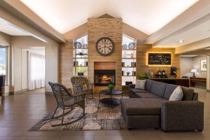 sala de estar con sofá y chimenea en Country Inn & Suites by Radisson, Wichita East, KS, en Wichita