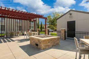 un patio avec un foyer extérieur et un bâtiment dans l'établissement Country Inn & Suites by Radisson, Wichita East, KS, à Wichita