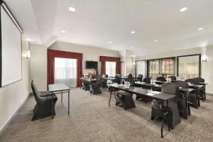 a conference room with tables and chairs and a screen at Country Inn & Suites by Radisson, Kansas City at Village West, KS in Kansas City