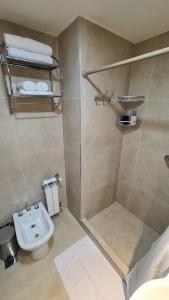 een badkamer met een douche, een toilet en een wastafel bij Nova Patagonia Apart Bariloche in Bariloche