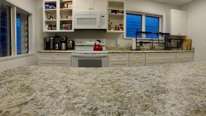 a kitchen with white cabinets and a marble counter top at Hotel on Magnolia East 'HOME' in Wildwood