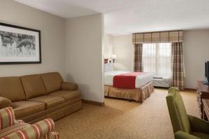 Habitación de hotel con cama y sofá en Country Inn & Suites by Radisson, Louisville South, KY, en Shepherdsville