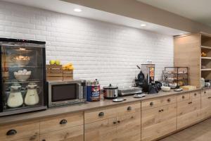 a kitchen with a counter with a microwave and appliances at Country Inn & Suites by Radisson, Louisville South, KY in Shepherdsville