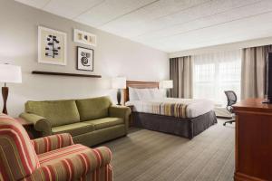 a hotel room with a bed and a couch at Country Inn & Suites by Radisson, Lexington, KY in Lexington