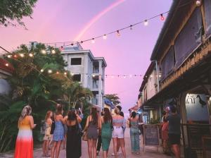 a group of women standing on a street under a rainbow at Two Ducks in Koh Rong Sanloem