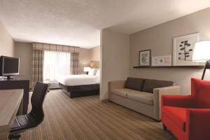 a hotel room with a bed and a living room at Country Inn & Suites by Radisson, Georgetown, KY in Georgetown